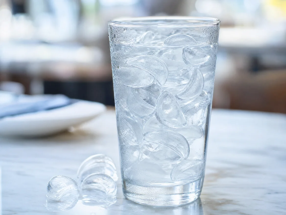 Crescent ice pieces in a tall glass of water Crescent ice pieces in a tall glass of water